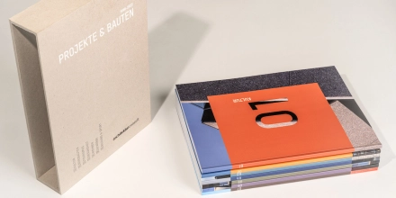 Ein Stapel mit den sieben Themenheften liegt neben dem Kartonschuber.